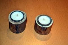 Kleine Teelichter im Glas in einem Holzstamm