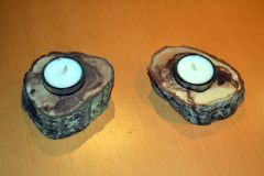Kleine Teelichter im Glas in einem Kirch-Holzstamm